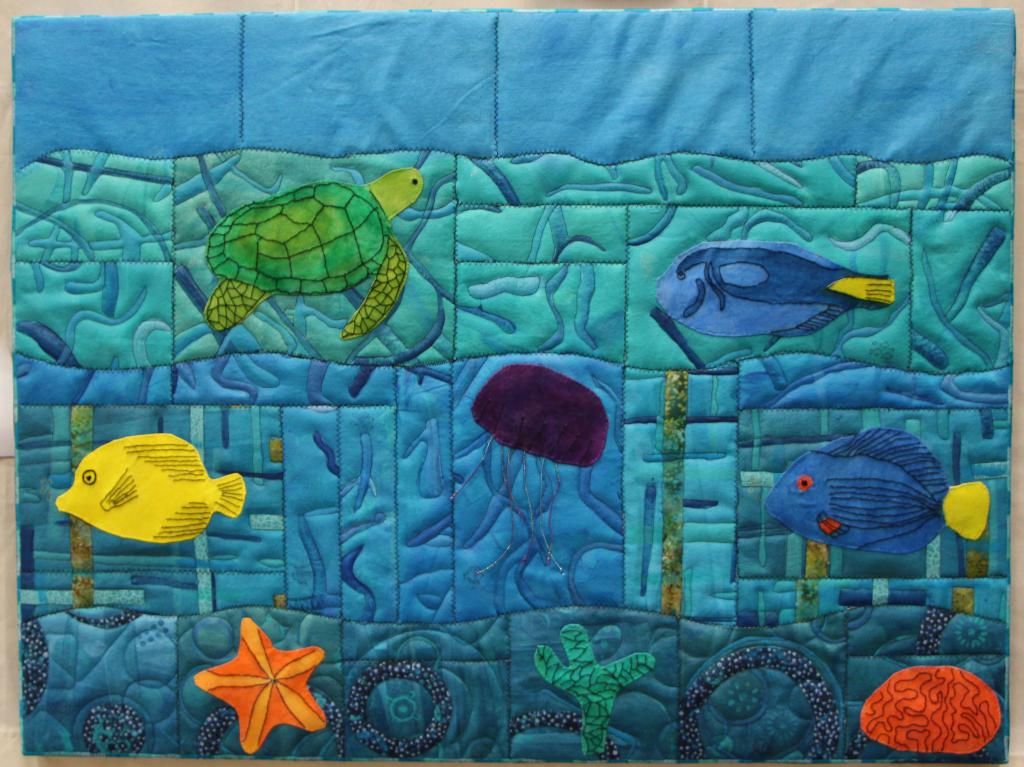 35" x 27.5"; Entered in the Cotton Patch Quilter's 2019 quilt show.  Watercolor painted tropical fish on zigzag stitched canvas.  It hangs in my office.